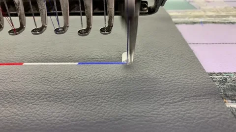 Industrial embroidery machine stitching above on textured synthetic leather Stock Footage 346812888