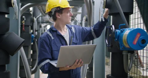 Industrial engineer in a hard hat uses a laptop for diagnostics Stock Footage 339481259