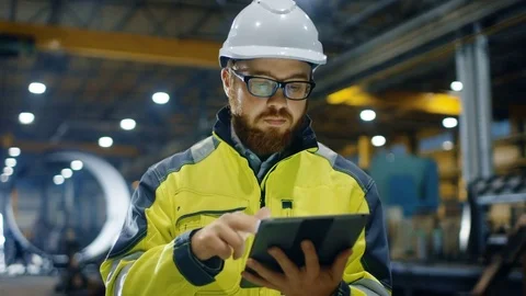 Industrial Engineer in Hard Hat Wearing Safety Jacket Uses Touchscreen Tablet  Stock Footage
