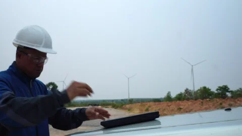 Industrial engineer in hard hat wearing wafety jacket uses touchscreen tablet  Video stock 127920024
