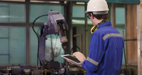 Industrial engineer using tablet check and control automation robot arms machine Stock Footage 152912982