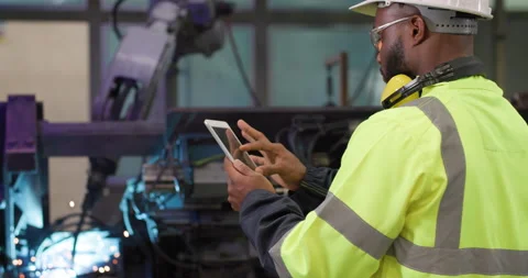 Industrial engineer using tablet check and control automation robot arms machine Stock Footage 183333054