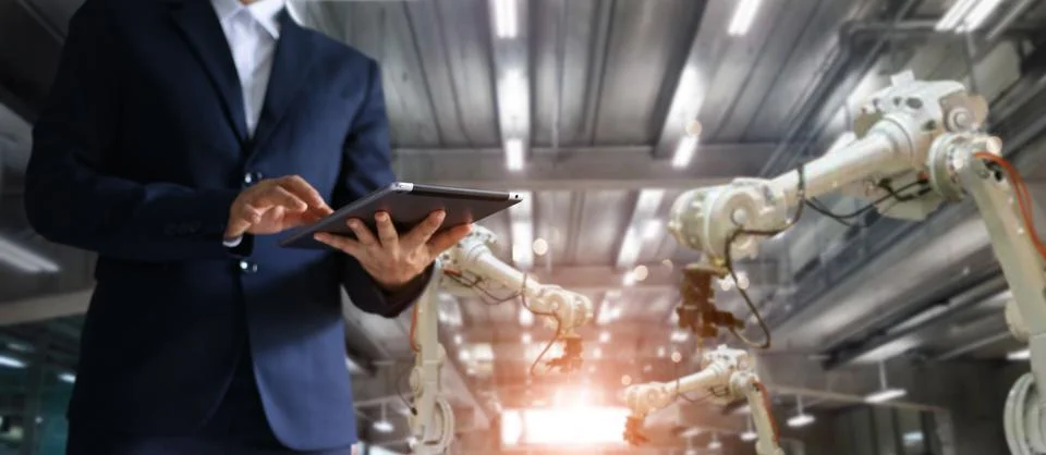 Industrial engineer using tablet controlling automation robot Stock Photos