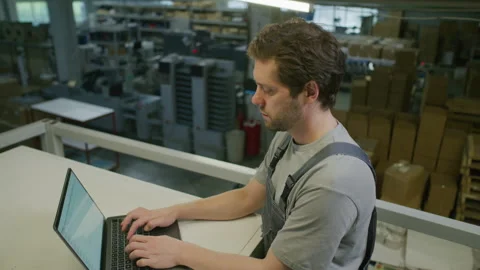 Industrial Engineer Working on Laptop in Warehouse of Printing Plant Stock Footage 335486664