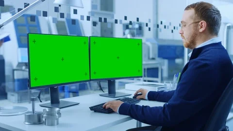 Industrial Engineer Working on Personal Computer Two Monitor Screens are Mock-up Stock Footage 123633920