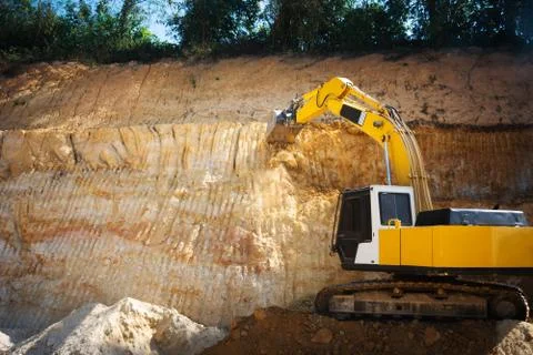 Industrial excavator working on construction site to clear the land of sand a Stock-Fotos
