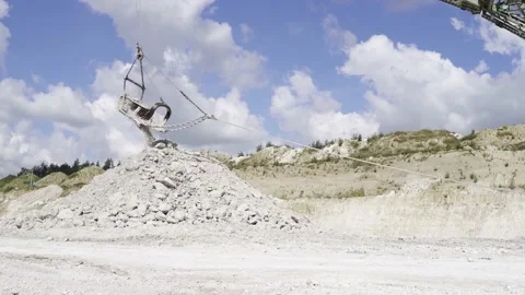 Industrial extraction of chalk in a large open pit. excavator pours a pile of Stock Footage 136679654