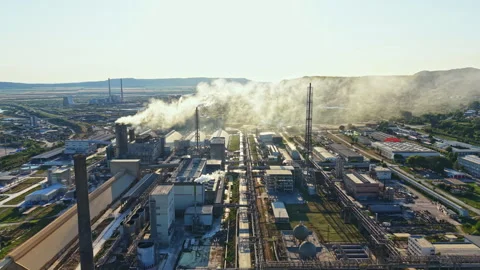 Industrial facility in operation during the day with smoke rising and equipment Stock Footage 341031292
