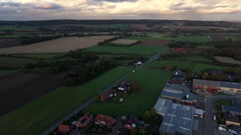 Industrial factory buildings border patchwork farm fields in rural American Stock Footage 348083176