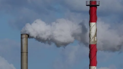 Industrial factory chimney stack emitting white smoke plumes into clear blu.. 库存影片 337753023