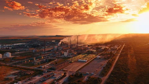 Industrial factory complex at sunset with bright orange clouds.. Smoke rises Stock Footage 340283887