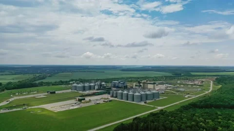 Industrial factory with grain elevators in field. Agriculture harvest storage Stock Footage 134592788