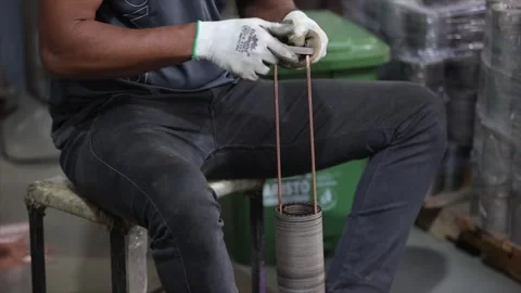 Industrial factory worker assembling heavy metal motor rotor components by Stock Footage 327804634