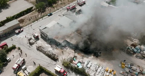 Industrial fire aftermath Firefighters work to suppress Video stock 303309489
