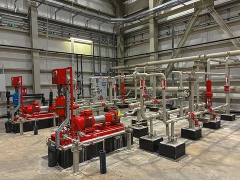 Industrial fire pump system inside a large facility and its control systems. Stock Photos