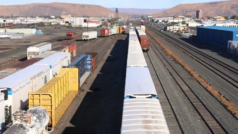 Industrial freight train moving on railway tracks through a large train yar.. Stock Footage 329660397