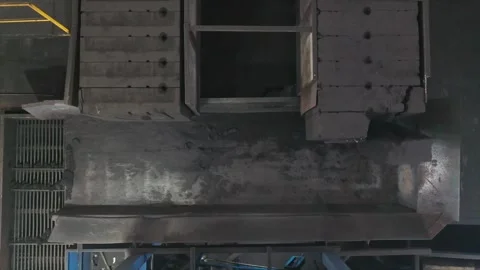 Industrial furnace or processing unit discharging raw dark mineral Stock Footage 325700985