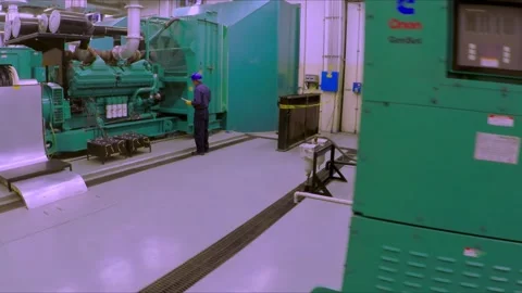 Industrial Generator Room with Engineer Inspecting Power Equipment in Modern Stock Footage 338133049