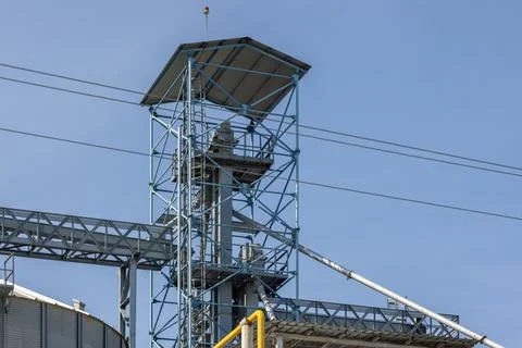 Industrial grain elevator structure in clear blue sky Stock Photos