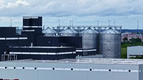 Industrial grain silos and processing plant with rooftop wind turbines Stock Footage 344522209