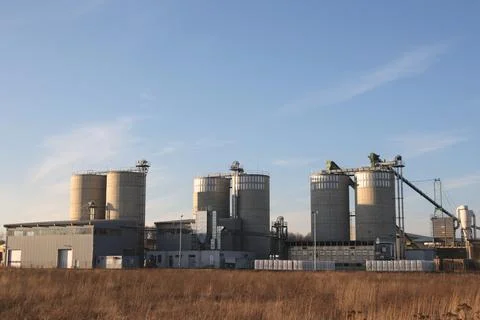 Industrial Grain Silos and Processing Plant Under Blue Sky Stock Photos
