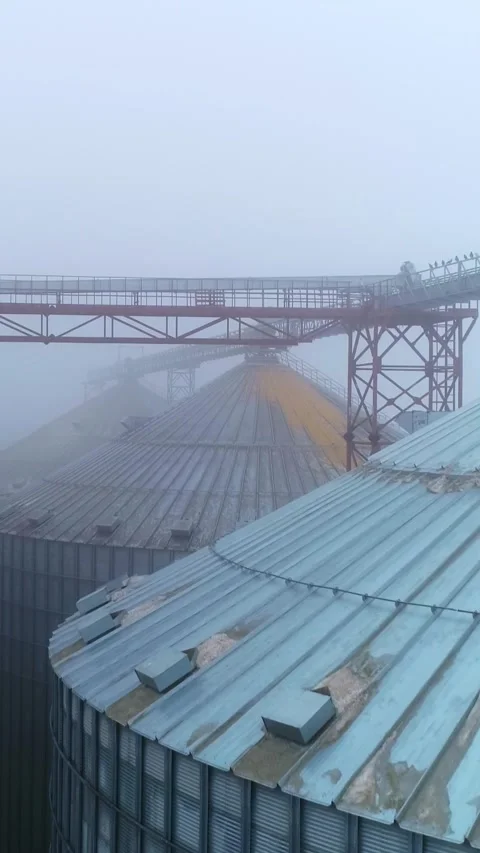 Industrial grain storage elevators and infrastructure on a misty morning wi.. Stock Footage 337682779