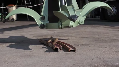 Industrial grapple arm in scrap yard attracting metal parts with its magnet Stock Footage 175174091