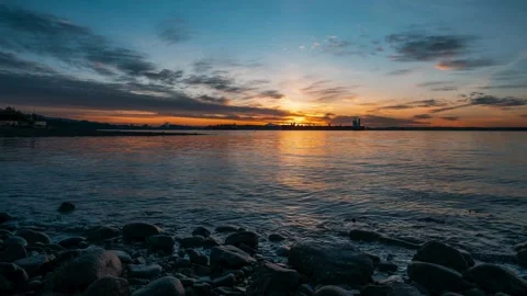 Industrial harbor sunset timelapse over rocky ocean beach Stock Footage 332874033