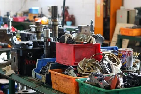 An industrial heavy duty workshop workbench with machinery parts and tool bin Stock Photos