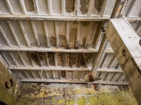 Industrial interior view of a derelict ceiling in an abandoned warehouse wi.. Stock Photos