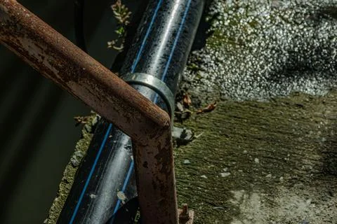 Industrial iron railing rust texture with plastic water pipe near midnight Stock Photos
