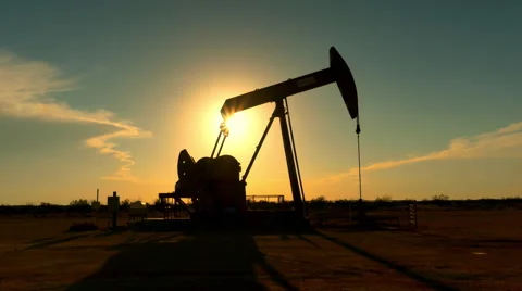 Industrial jack pump platform pumping crude oil over sunset sun Stock Footage 62221435