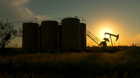 Industrial jack pump platform pumping crude oil against sunset sun Stock Footage 62222159