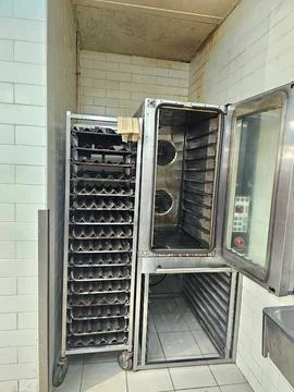 An industrial kitchen features a large, open commercial oven Fotos Stock