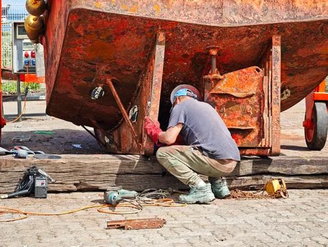 Industrial labor: Skilled worker performing maritime vessel maintenance at .. Stock Photos