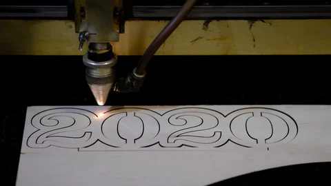 Industrial laser is cutting a pattern, numbers 2020, on a plywood sheet . Stock Footage 120712643