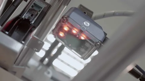 An industrial laser sensor on a conveyor detects the passage of a goods Stock-Footage 167564442