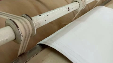 In an industrial laundry, a large drum press for ironing clothes is spinning Stock Footage 160829819