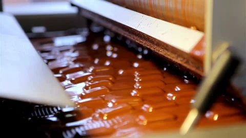 Industrial machine coating confectionery bars with liquid milk chocolate Stock-Footage 333829071