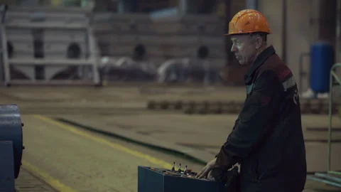 Industrial machine operator pressing buttons on the control panel at the factory Stock Footage 303581471