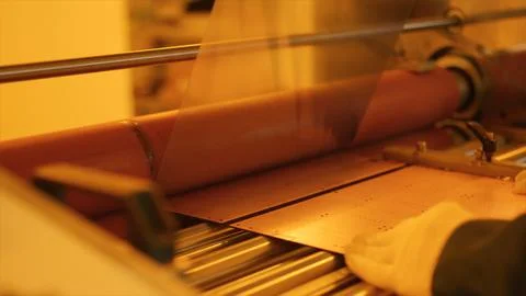 Industrial machine processing copper sheet in manufacturing plant Stock Photos