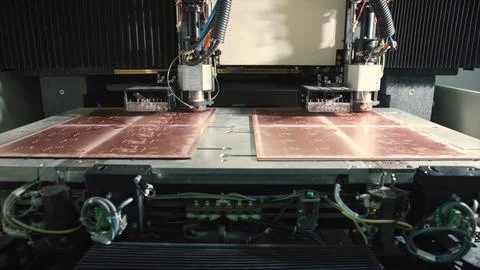 Industrial machinery processing copper sheets in manufacturing plant Stockfoto's