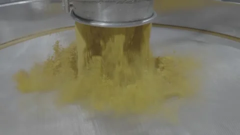 Industrial machinery processing yellow powder on a vibrating sieve. Stock-Footage 330154946