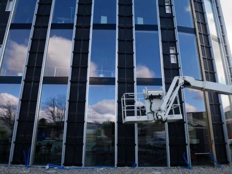 Industrial maintenance work using a hydraulic cherry picker lift near a ref.. Stockfoto's