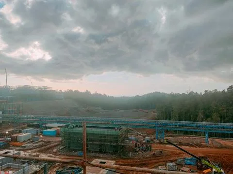 Industrial Mining Facility Under Dramatic Storm Clouds at Sunset Stock Photos