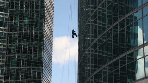 Industrial mountaineering. Window cleaner performs work between two skyscrapers Stock Footage 220852018