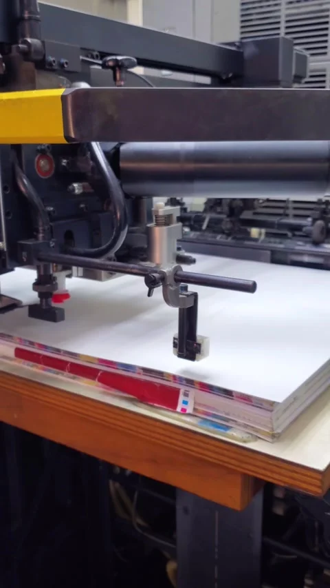 Industrial offset printing press machine in operation feeding paper sheets with Stock Footage 336888316