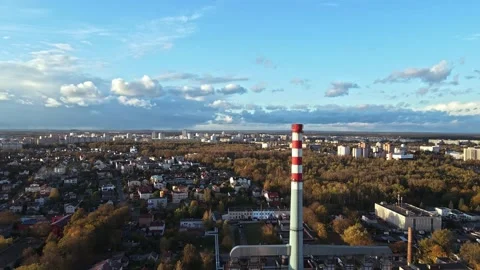 Industrial Pipe in front of city with clouds passing through blue sky Stock Footage 142948140