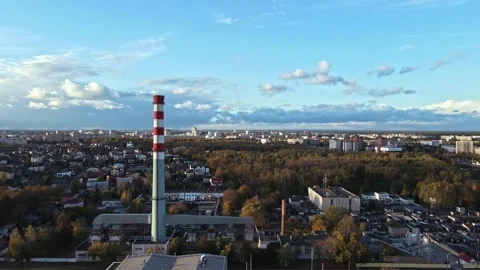 Industrial Pipe in front of city with clouds passing through blue sky Stock Footage 142948408