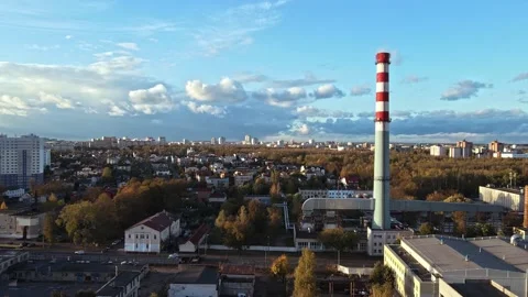 Industrial Pipe in front of city with clouds passing through blue sky Stock Footage 142949003